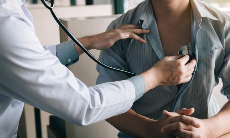 doctor using a stethoscope listen to the heartbeat of the elderly patient