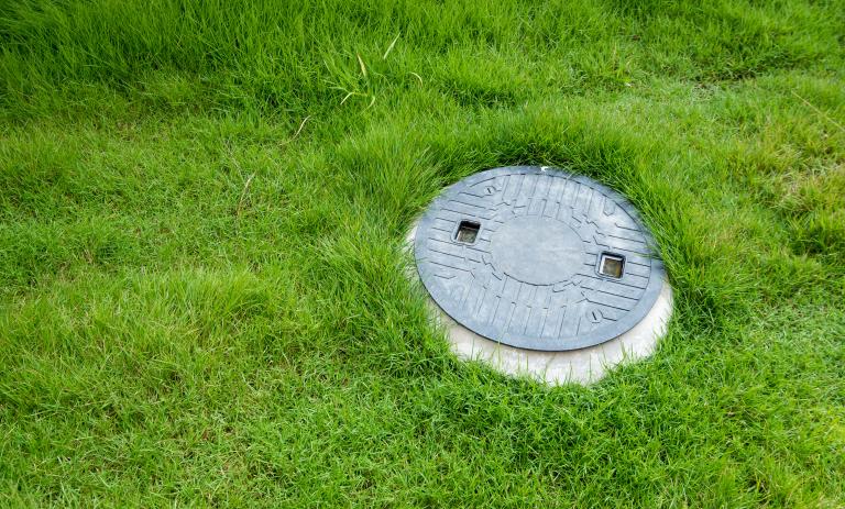 An access point to an underground septic tank in a lawn