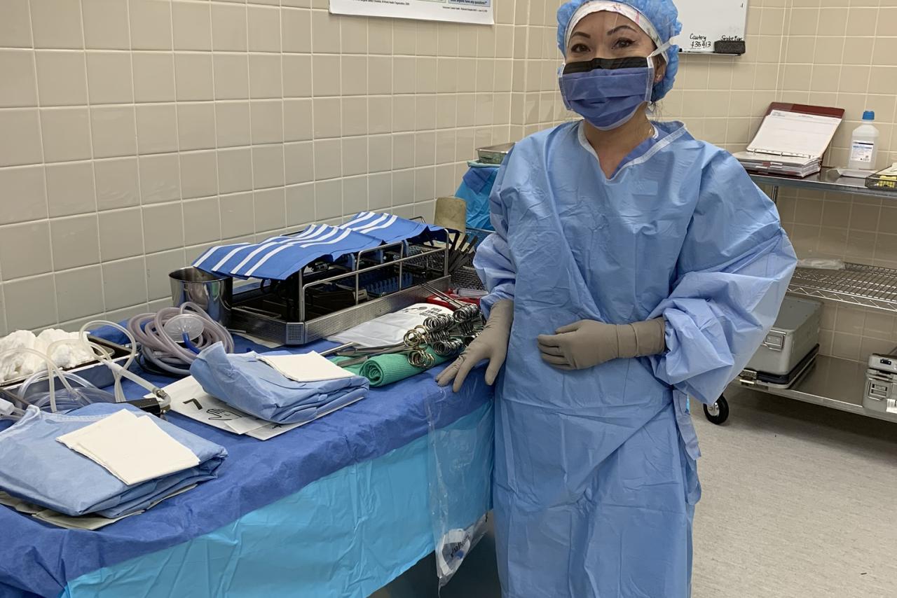 Mary Luu, LPN, standing in an operating room while wearing work scrubs.