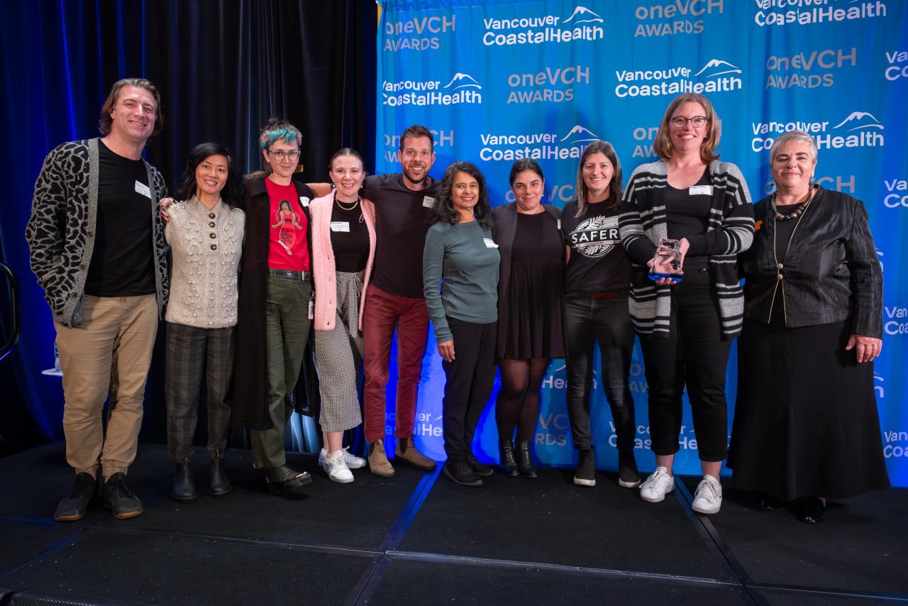 VCH staff and leaders posing for a photo on the stage of the oneVCH awards