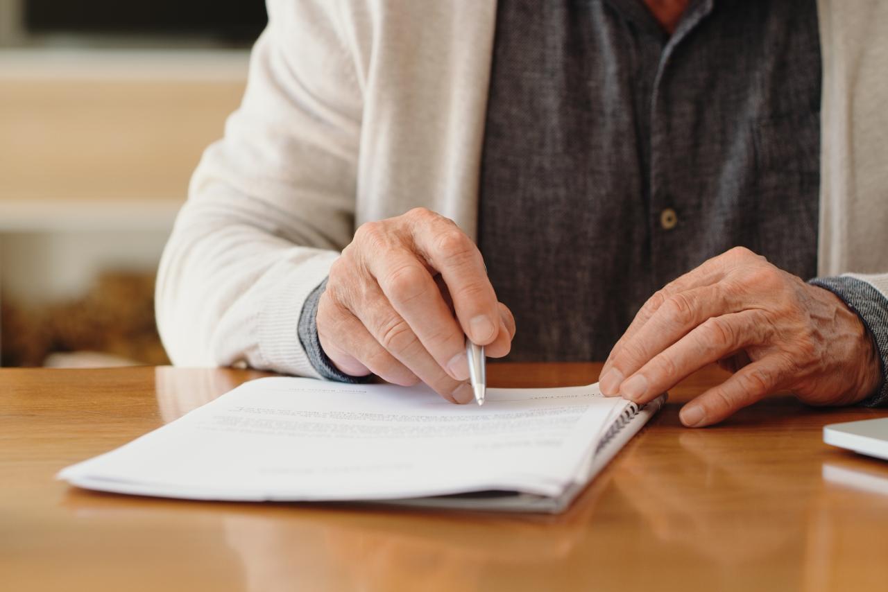 adult writing on a notepad