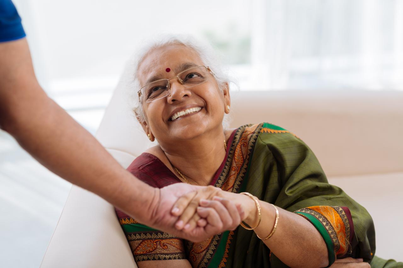 happy senior woman holding the hand of a caretaker