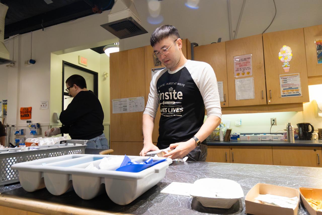 VCH Clinical Coordinator Kyle Yrjola prepares harm reduction supplies at the Insite nurses’ station; VCH Nurse Educator Dar Michaleski is in the background.