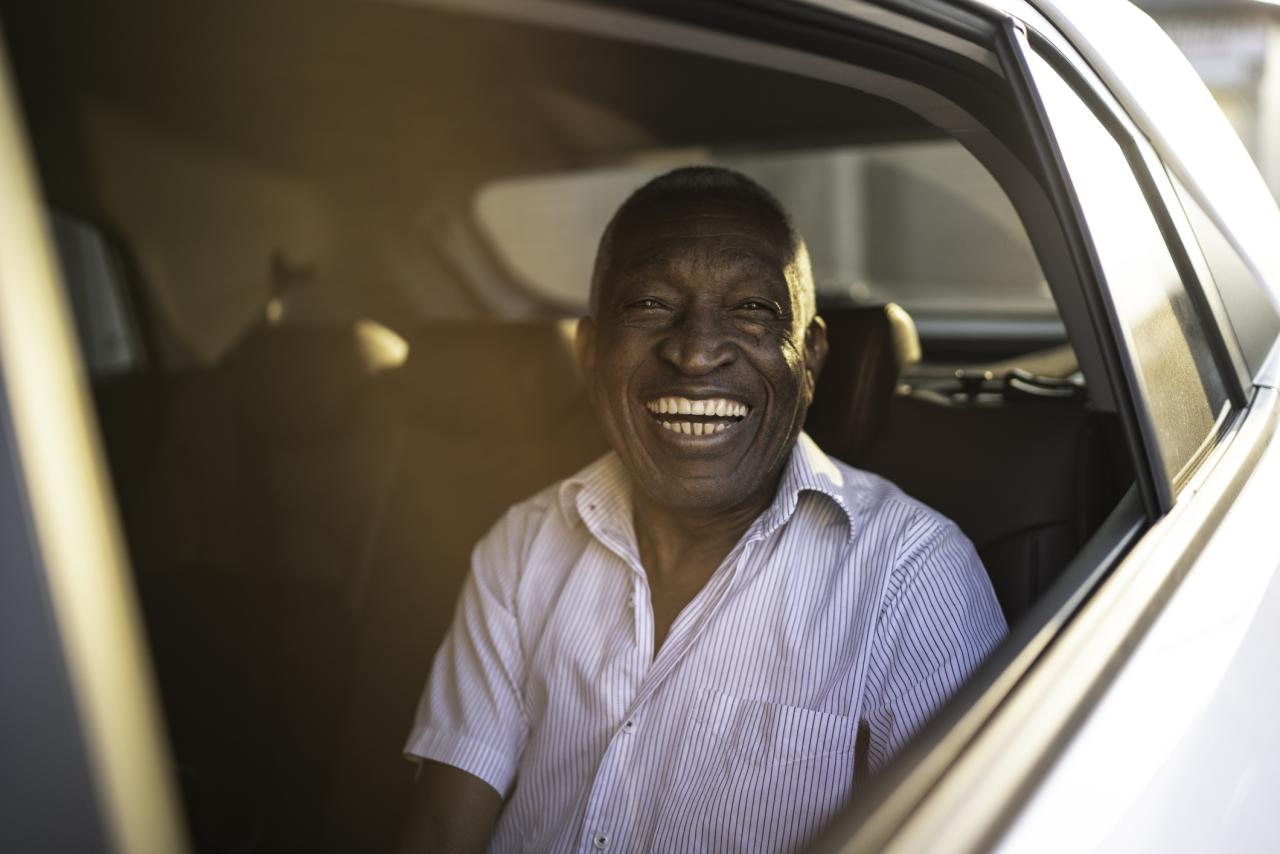 Portrait of happy senior in passenger seat of a car.