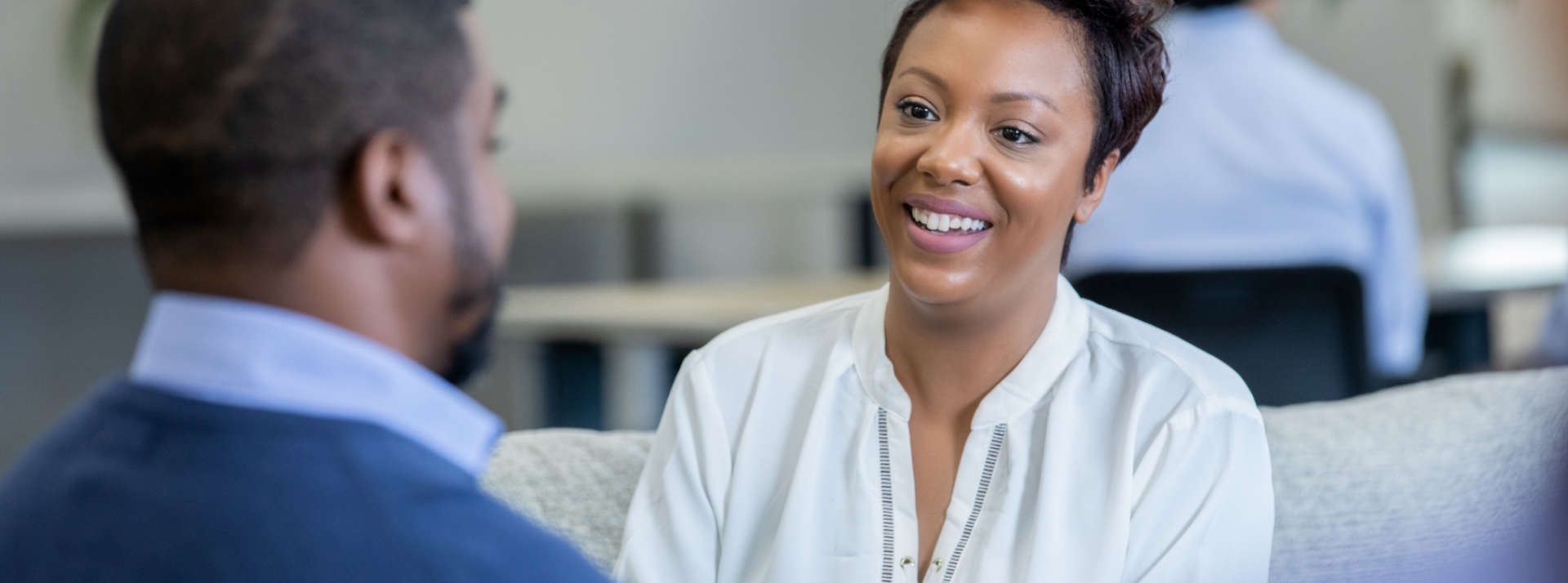 Person sitting with tablet device in their hand, looking at client speaking.