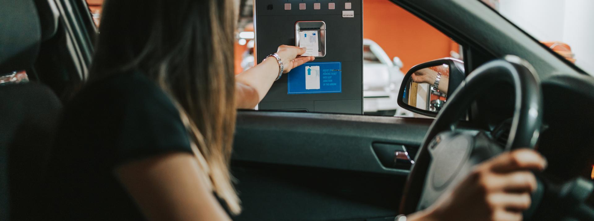 Driver using automated parking service to enter into a garage.