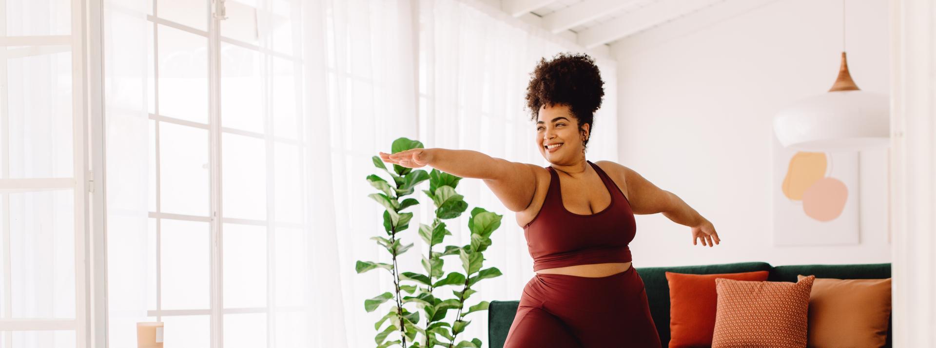 A person in their living room doing yoga in workout clothing