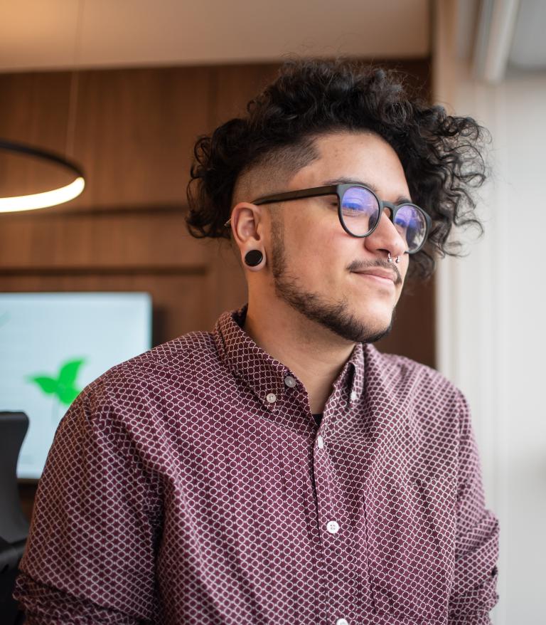 a transgender man look at a tranquil view through a window