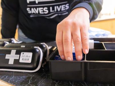 Preparing harm reduction supplies including take-home naloxone kits.