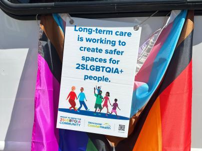 A parade sign saying Long-term care is working to create safer spaces for 2SLGBTQIA+ people